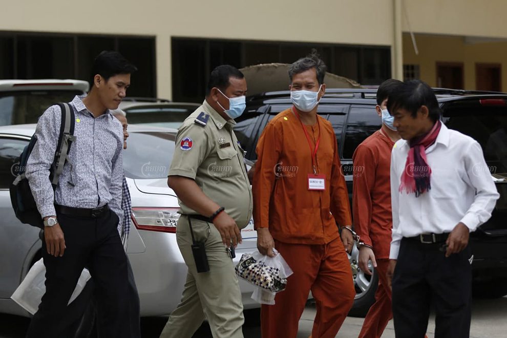 Former RFA journalists Yeang Sothearin, left, and Uon Chhin, right, and RT fixer Rath Rott Mony, center, leave the Supreme Court in Phnom Penh after a hearing on July 1. Panha Chhorpoan