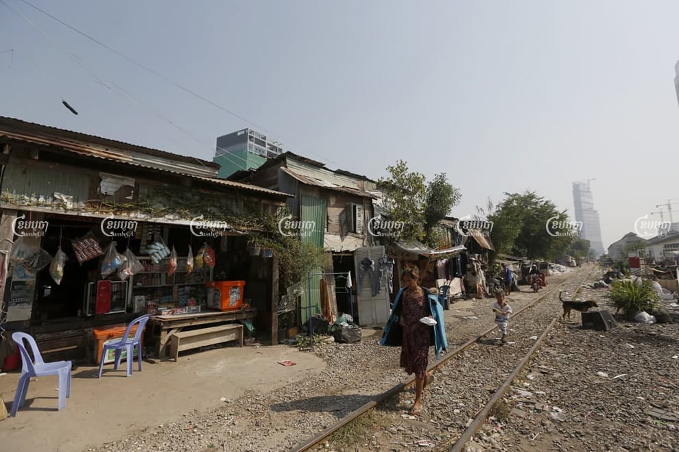 A resident and her child kid walk along the railway line in Toul Kork district on January 15. Panha Chhorpoan