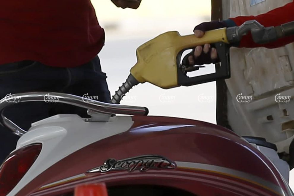 A worker pours gasoline into a customer’s motorbike at a gas station in Phnom Penh. Panha Chhorpoan