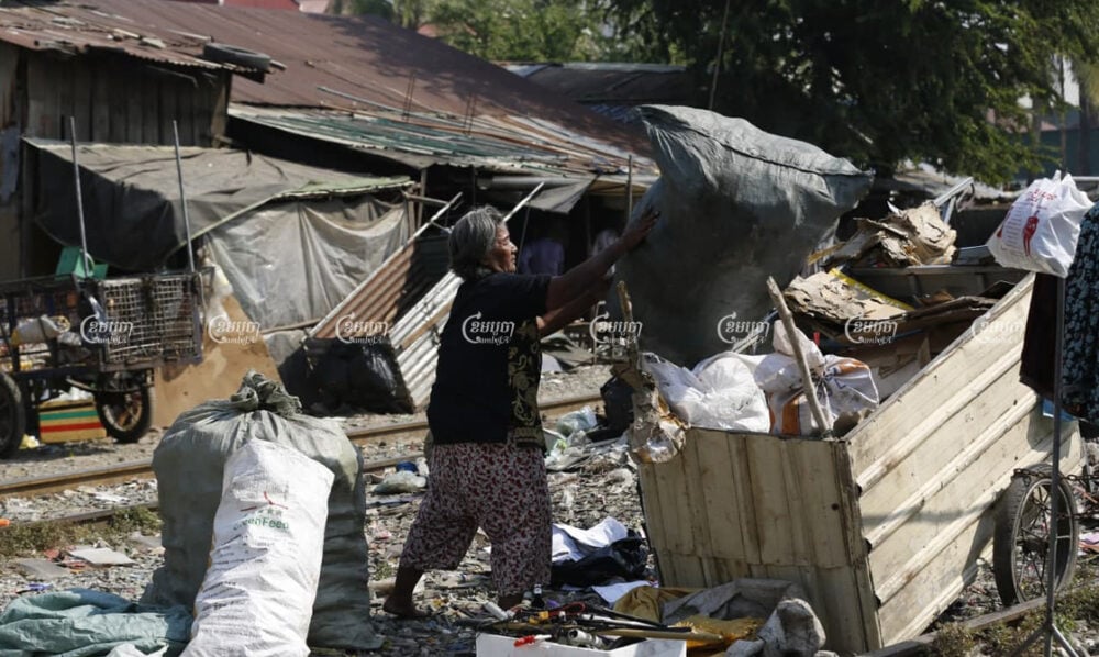 Iev Mach empties recyclables into a cart near her home in Toul Kok district, where her community is facing eviction to make way for a new road and drainage system, on January 15. Panha Chhorpoan