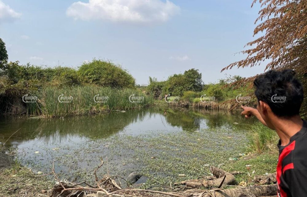 Kampong Speu resident Lay Ratha points to the O'Brong stream, which he said is now polluted and undrinkable after the opening of a new factory nearby. Sorn Sarath