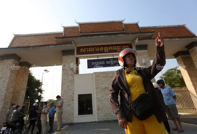 Sao Na stands in front of the Kandal Provincial Hall on Friday before receiving compensation along with 1,000 others in a long-running dispute with her former employer. CamboJA/Pring Samrang