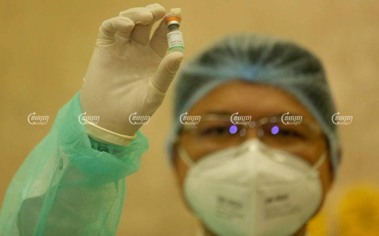 A medial staffer inspects a dose of the Covid-19 vaccine during the 1st day of injections at Phnom Penh’s Calmette Hospital last month. CamboJA/ Pring Samrang
