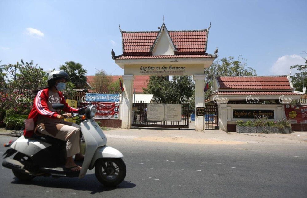 A woman drives past a closed school in Phnom Penh, March 11, 2021. CamboJA/ Pring Samrang