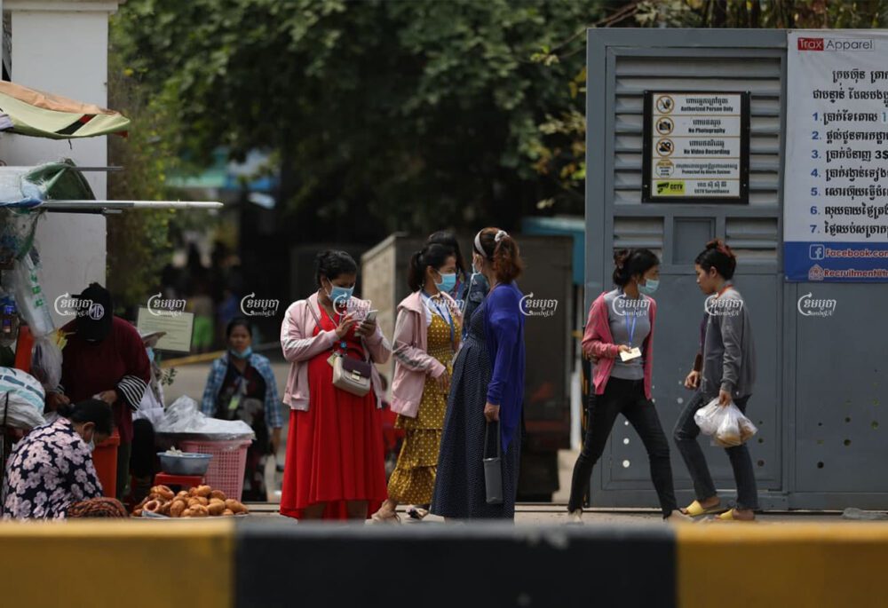 Garment workers buy food in front of the Trax Apparel factory, one day after a factory guard was brought to the hospital upon testing positive for Covid-19, March 17, 2021. CamboJA/ Pring Samrang