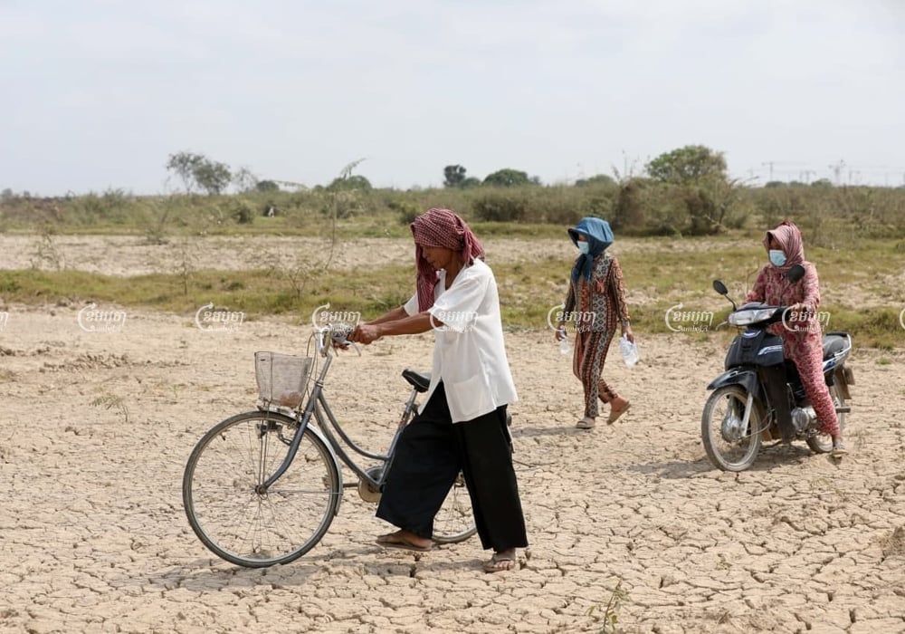 Villagers walk on the land where construction on the airport has begun in Kandal province, March 2, 2021. CamboJA/ Pring Samrang