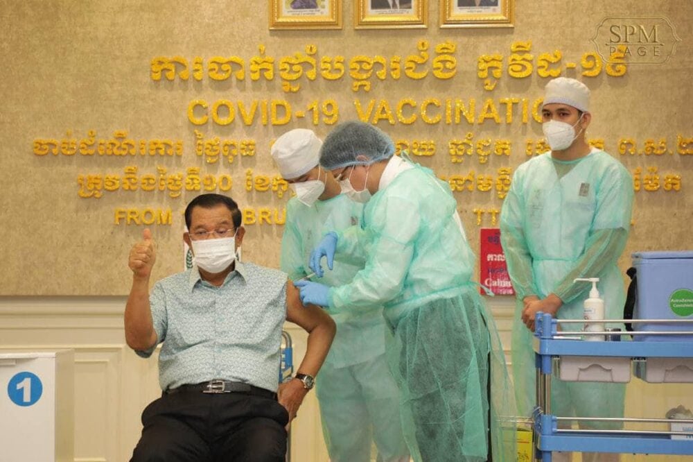 Prime Minister Hun Sen gives a thumbs up to reporters as he gets his first dose of the AstraZeneca vaccine on Thursday at Phnom Penh's Calmette Hospital. Hun Sen’s Facebook