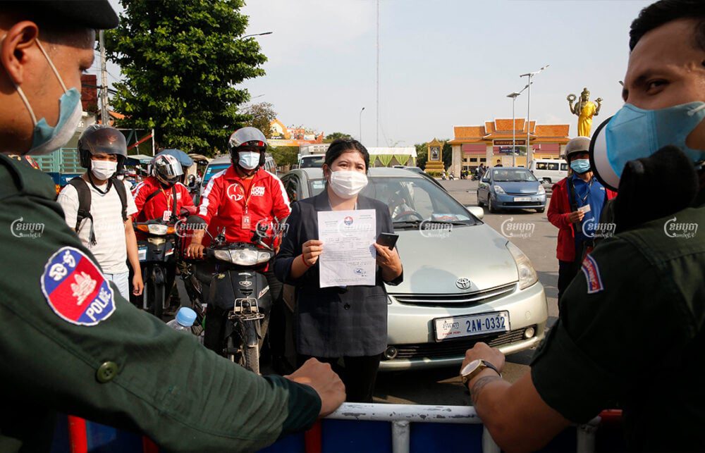 A female journalist displays a travel permission letter to police at the Phnom Penh-Kandal Police barricade of the first day of lockdown, April 15, 2021. CamboJA/ Panha Chhorpoan