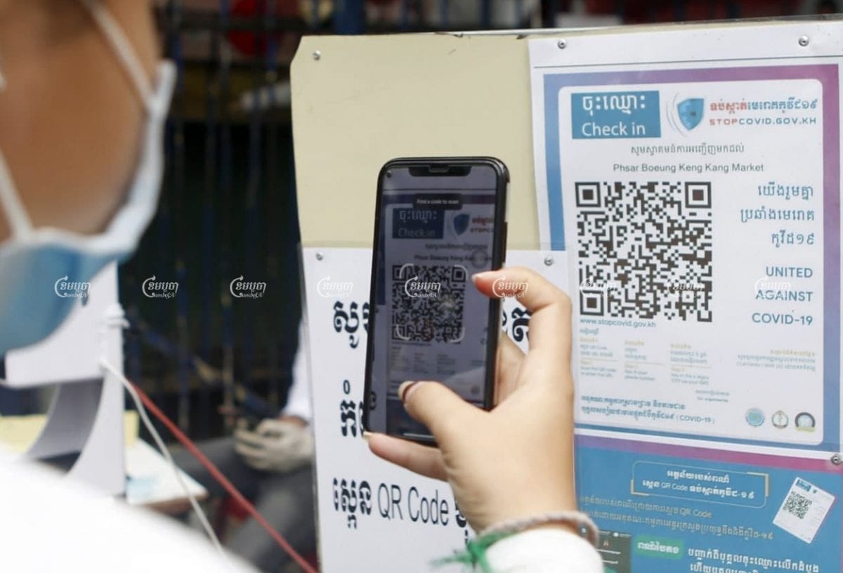A woman scans a QR Code when entering a market in Phnom Penh, April 6, 2021. CamboJA/ Pring Samrang