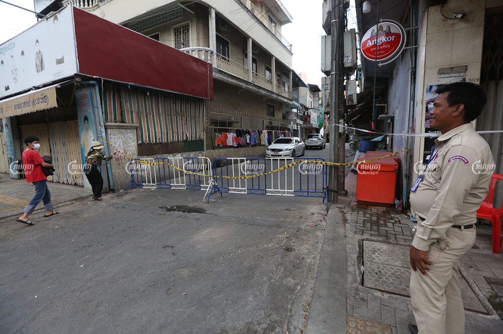 Residents walk past a barrier placed in front of a Phnom Penh road, April 19, 2021. CamboJA/ Pring Samrang