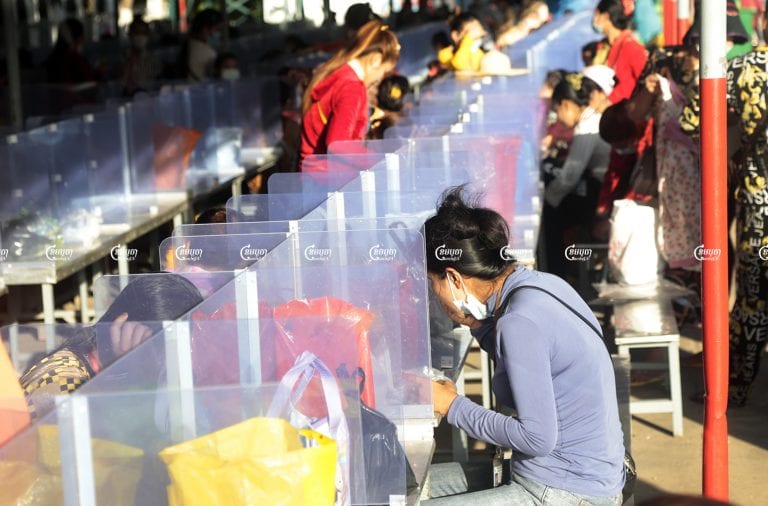 Garment workers eat breakfast separated by plastic partitions at a factory at Kakap II commune Pur Senchey district in Phnom Penh, June 14, 2021. CamboJA/ Panha Chhorpoan