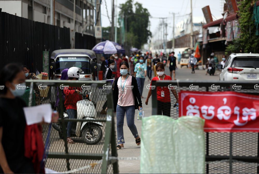 Garment workers return to their rental rooms after receiving COVID-19 vaccinations in a red zone in the locked-down Choam Chao 1 commune of the Pur Senchey District in Phnom Penh. Picture taken on May 12, 2021. CamboJA/ Pring Samrang