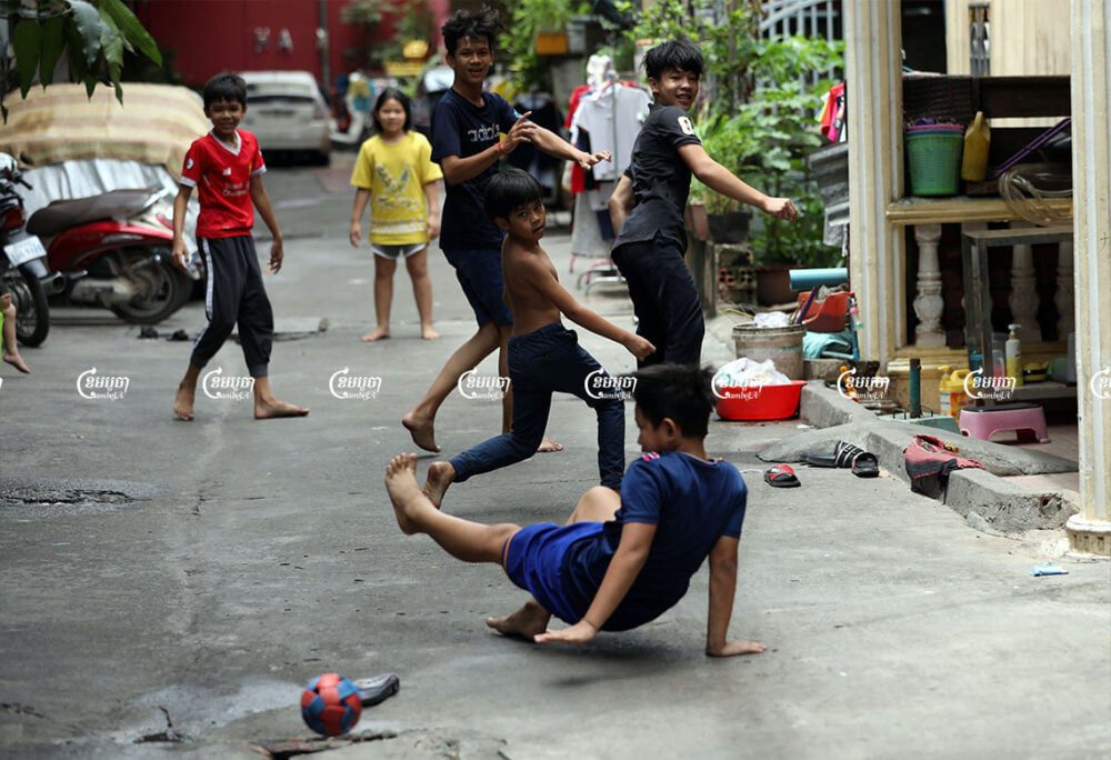Children play football at a village in Phnom Penh. Cambodia's PM Hun Sen says the country wants to begin offering COVID-19 vaccinations to children, July 16, 2021. CamboJA/ Pring Samrang