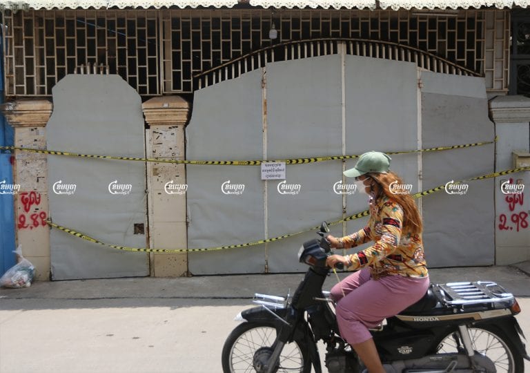 Motorists drive past a house where people are undergoing home treatment for Covid-19 in Phnom Penh, July 12, 2021. CamboJA/ Pring Samrang