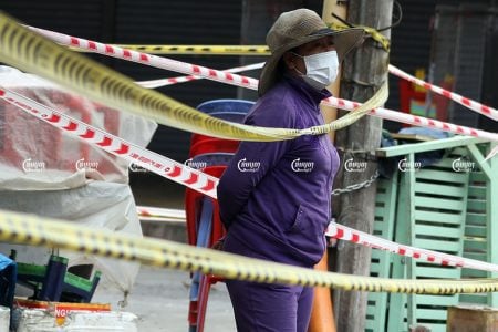 A woman stands in front of her home near the locked-down market in Phsar Chas commune, Daun Penh district in Phnom Penh, August 23, 2021. CamboJA/ Pring Samrang