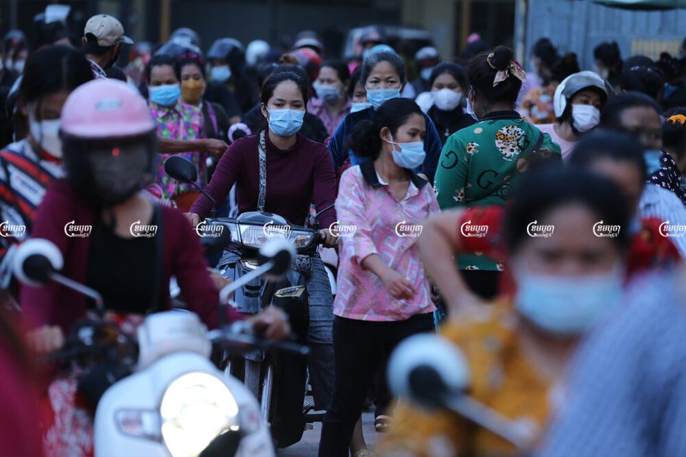 Garment workers on the outskirts of Phnom Penh leave their factory after finishing their work. August 18, 2021. CamboJA/ Panha Chhorpoan