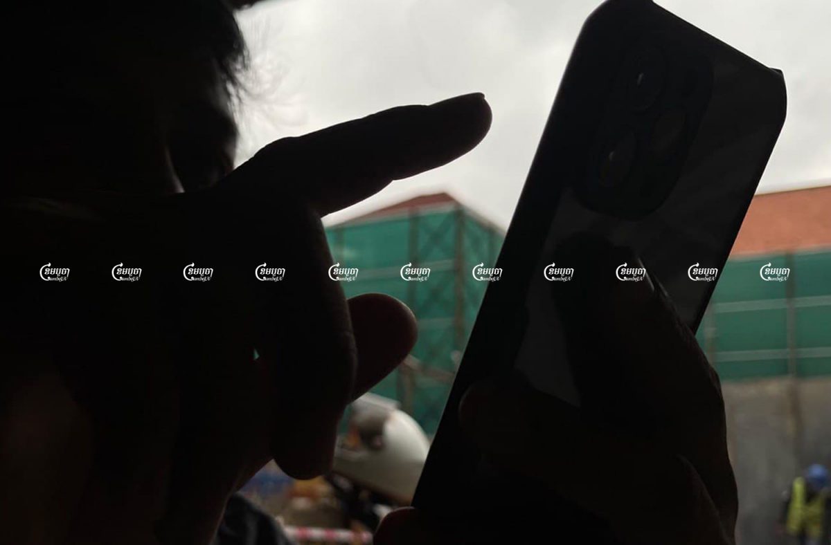 A man uses his smartphone at a coffee shop along a street in Phnom Penh, September 1, 2021. CamboJA/ Pring Samrang