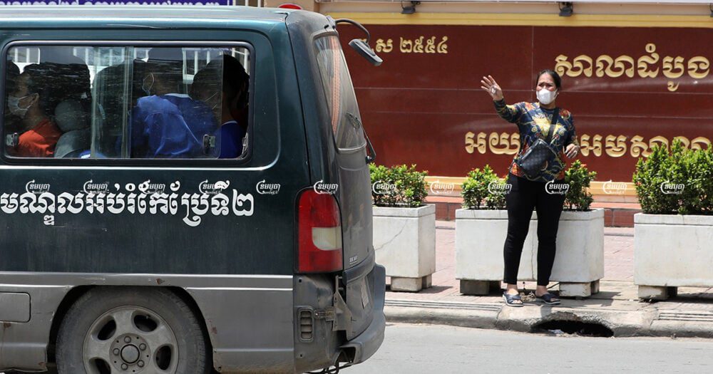 Kak Sovann Chhay's mother Prum Chantha waves to her son in the prisoner's van in front of the Municipal Court of Phnom Penh after his hearing, September 29, 2021. CamboJA/ Pring Samrang
