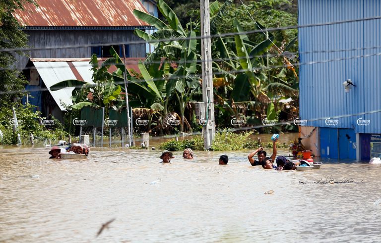 People carry their belongings out of their flooded home in Dangkor district's Kongnoy commune in Phnom Penh, October 26, 2021. CamboJA/ Panha Chhorpoan