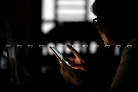 A woman uses her smartphone to look at social media in Phnom Penh, November 25, 2021. CamboJA/ Pring Samrang