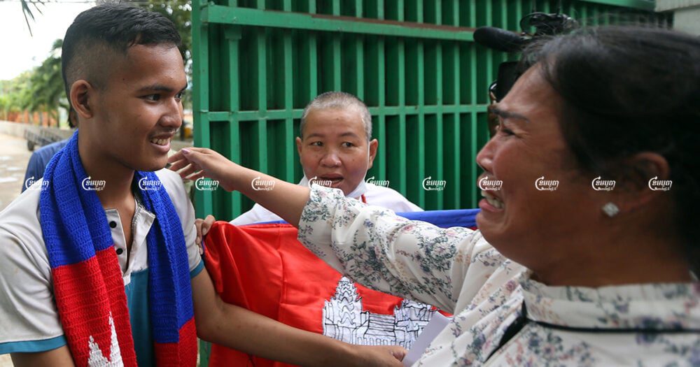 Kak Sovann Chhay smiles as his mother Prum Chantha cries and hugs him after his release from jail in Phnom Penh, November 10, 2021. CamboJA/ Pring Samrang