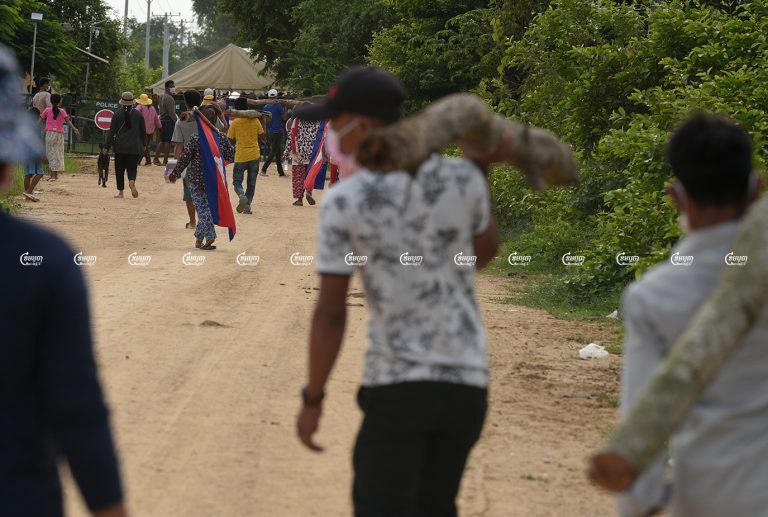 Villagers demonstrate in front of police barricades where authorities had blocked a road leading to the villagers' farmland. The disputed land is being cleared as part of the site of the planned mega-airport project in the Kandal Stung district of Kandal province. Picture taken September 12, 2021. CamboJA/ Panha Chhorpoan