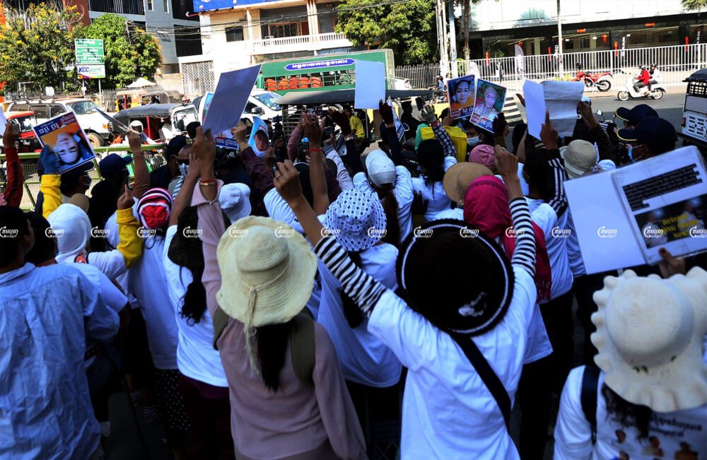 Supporters of political opposition activists are blocked by police officers near the Phnom Penh Municipal Court as a Prey Sar prison vehicle returns former CNRP officials to the prison after a court hearing. Picture taken February 18, 2021. CambodJA/ Pring Samrang