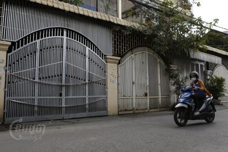 A woman drives past a house from which a family member tested positive for Omicron variant in the Meanchey district of Phnom Penh. CamboJA / Panha Chhorpoan