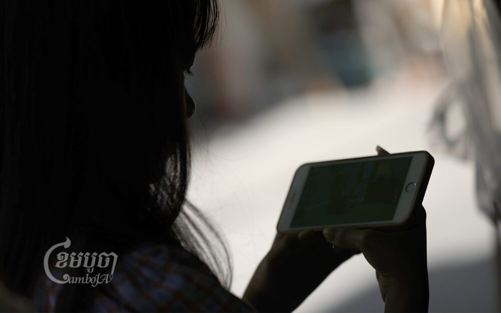 A young girl using a smart phone in Phnom Penh, May 13, 2022. CamboJA/ Pring Samrang