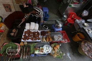 A woman sells food on a street in Phnom Penh. Photo taken on May 23, 2022. (CamboJA/ Pring Samrang)