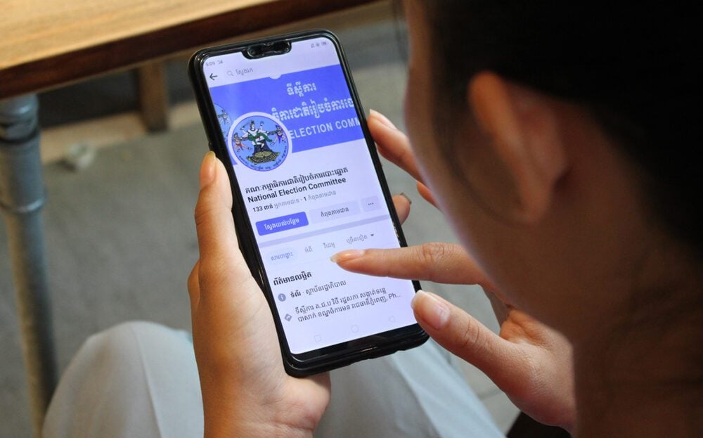 Karry Lek, an indigenous Brao woman from Ratanakiri province, checks the National Election Committee (NEC) Facebook page at a cafe shop in Phnom Penh on December 17, 2022. (CamboJA/Tuy Engly)