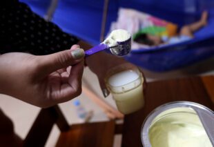A nanny prepares milk formula for a child in Phnom Penh. (CamboJA/ Pring Samrang)