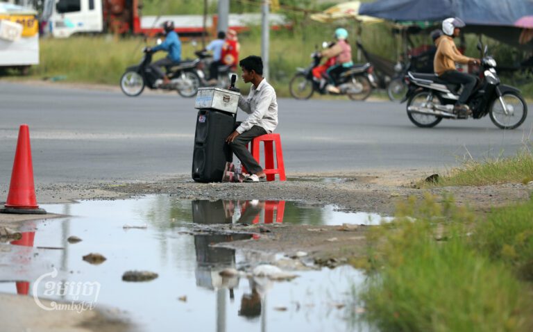 A man with disability sings for tips along a street on the outskirts of Phnom Penh on August 4, 2023. (CamboJA/Pring Samrang)