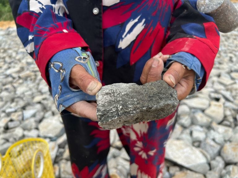 A villager holds a piece of waste ore left by a gold mining company in Kratie province in 2023. (Equitable Cambodia)