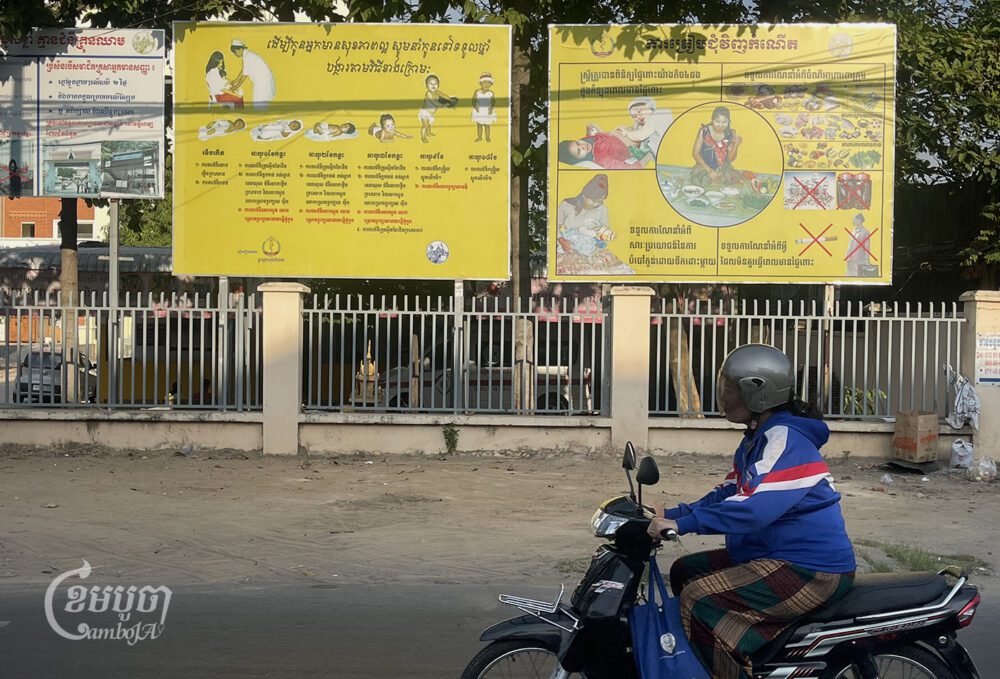 A woman rides a motorcycle past the Chak Angrekrom Health Center in Phnom Penh on January 8, 2024. (CamboJA/ Pring Samrang)
