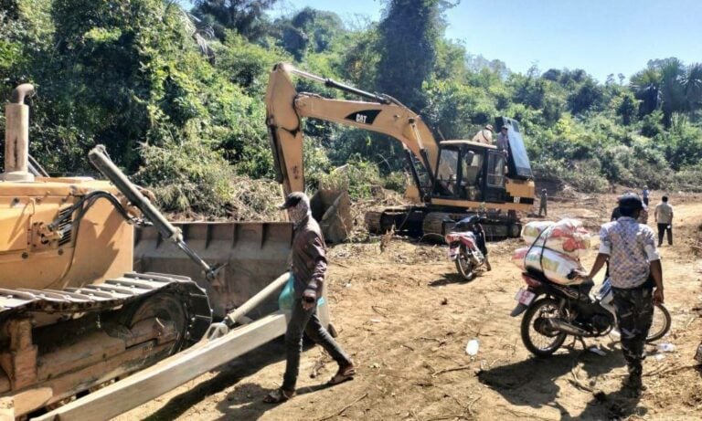 Villagers gather to prevent Global Green’s excavator and bulldozer from clearing their land to create access to the mine, January 13, 2024. (Supplied)
