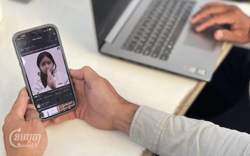 A man watches a video posted by a girl on social media calling for help, March 11, 2024. (CamboJA/Pring Samrang)