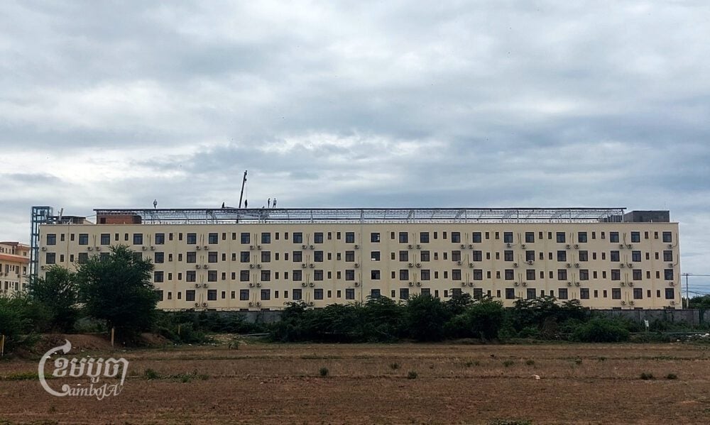 Workers walk on a rooftop structure of one building in the Golden Fortune Resorts World Casino compound in Kandal province’s Sampov Poun city on June 10, 2024. (CamnoJA/Danielle Keeton-Olsen)