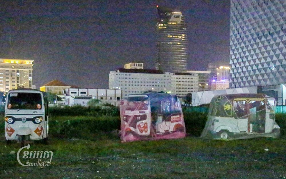 Drivers of ride-hailing services sleep in their vehicles, which are covered with mosquito nets, in an empty plot in Boeng Kak in Phnom Penh on June 16, 2024. (CamboJa/ An Vichet)