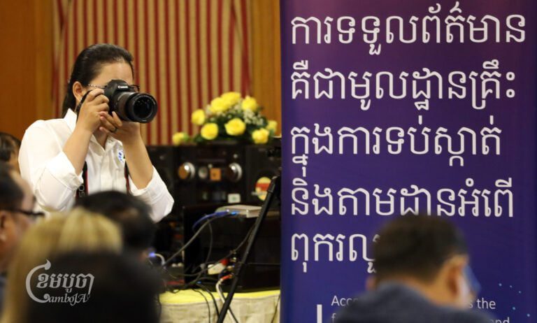 A female photographer takes pictures at the National Workshop for Universal Access to Information in Phnom Penh on September 27, 2024. (CamboJA/Pring Samrang)
