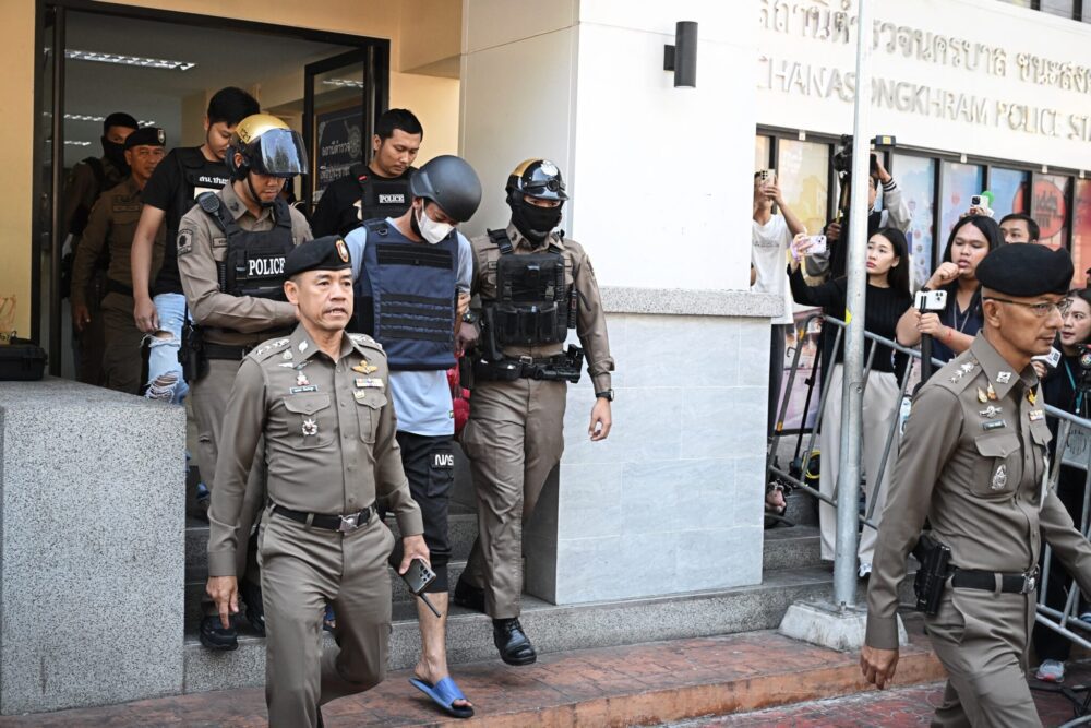 Thai national Ekalak Paenoi (C), a suspect in the alleged killing of former lawmaker of the dissolved Cambodia National Rescue Party (CNRP) Lim Kimya, is escorted into a police van to transport him to the Criminal Court from Chana Songkram Police Station in Bangkok on January 13, 2025. (Photo: AFP)