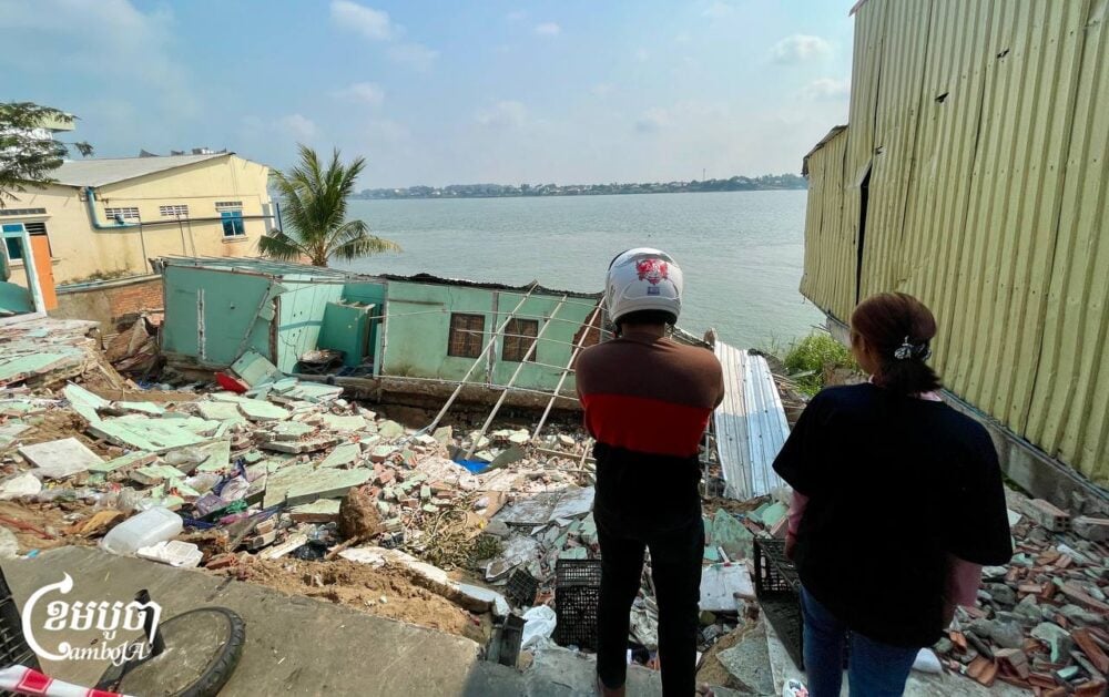 People look at the collapsed houses along the Mekong river in Phnom Penh, on February 3, 2025. (CamboJA/Pring Samrang)