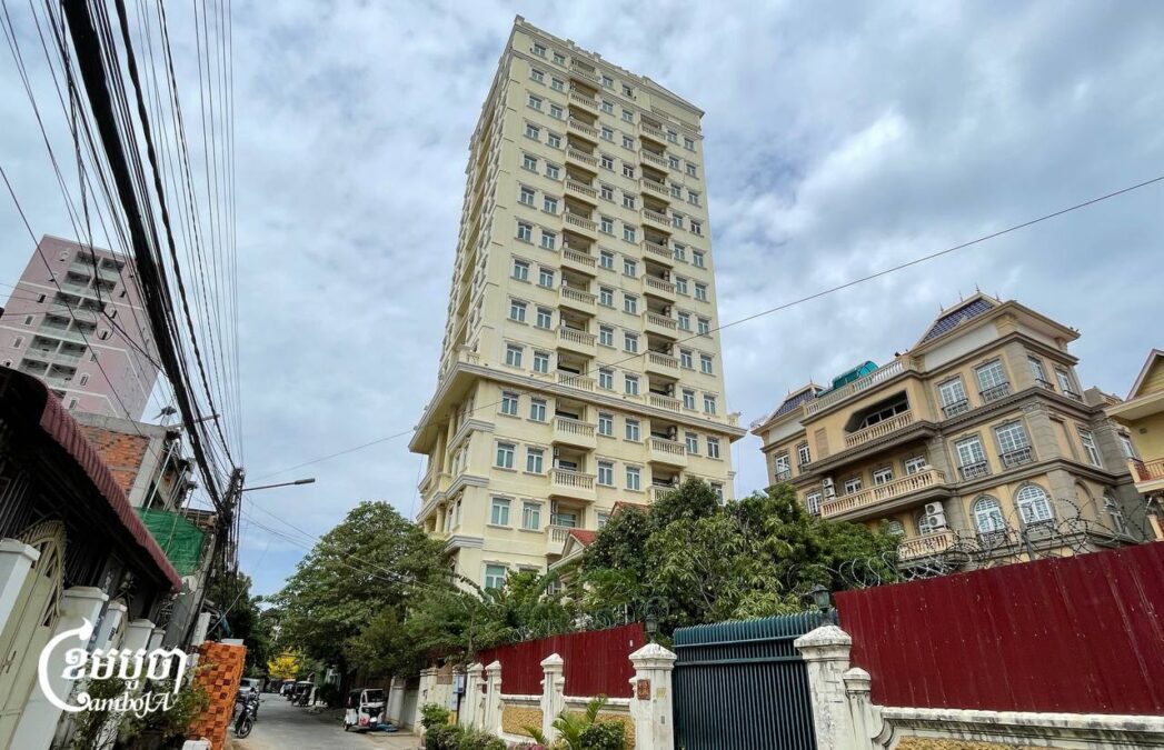 A 20-story apartment complex in Phnom Penh’s Chamkar Mon district, fortified with razor wire and security cameras, where police raided nearly 200 scammers. Photo taken April 2, 2025. (CamboJA/Pring Samrang)