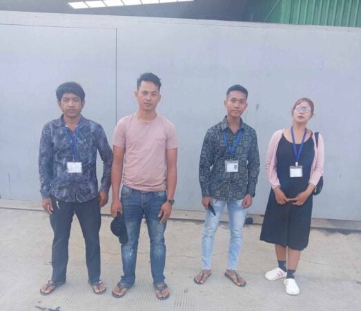 Four unionists stand in front of their factory, a photo posted on FUFI’s Facebook, April 21, 2025.