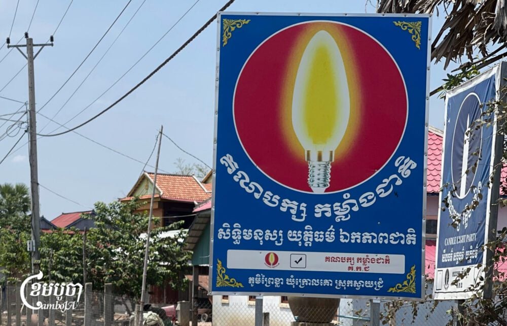 Candlelight Party and National Power Party signboards on a street in Svay Rieng province on April 5, 2025. (CamboJA/ Pring Samrang)
