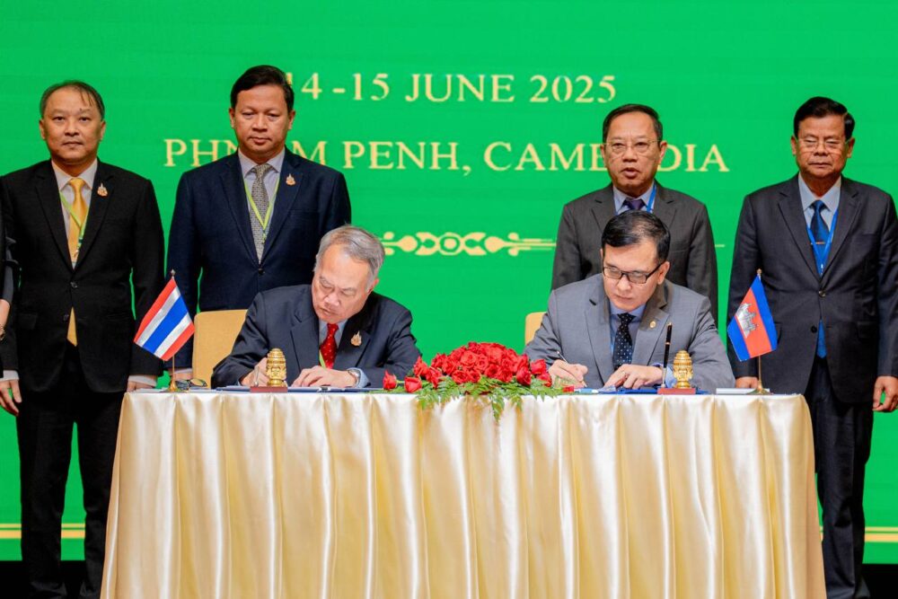 Cambodian border affairs minister Lam Chea and Thai foreign ministry adviser Prasas Prasasvinitchai sign JBC outcome on Sunday after two days of meeting in Phnom Penh. (AKP)