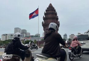 Motorists drive near the Independence Monument roundabout, which bears the Cambodian flag, in central Phnom Penh, July 21, 2025. (CamboJA/Pring Samrang)