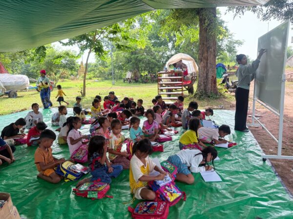 A community volunteer of World Vision Cambodia teaches children at a camp shelter at Preah Vihear province. (Photo: World Vision Cambodia)