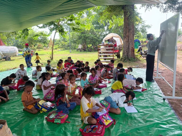 A community volunteer of World Vision Cambodia teaches children at a camp shelter at Preah Vihear province. (Photo: World Vision Cambodia)