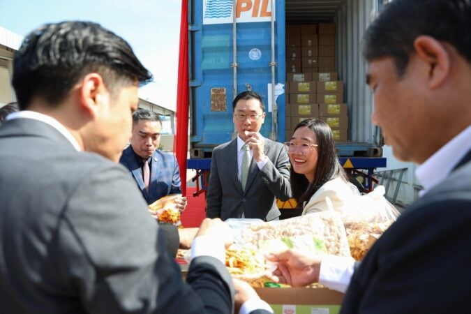 Australian Ambassador to Cambodia Derek Yip tastes the samples of locally produced dried fruit and nuts during the send-off of Royal Trust Trading Co., Ltd.’s inaugural shipment to Australia on August 14, 2025. (Photo: Khiev Chakriya/CAPRED)